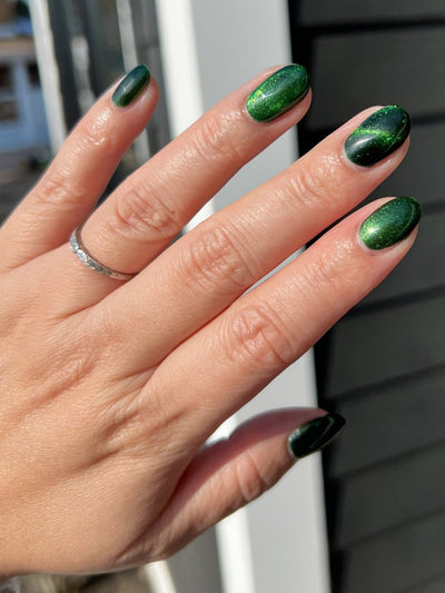 New Divide by Danglefoot Nail Polish, green shimmer jelly magnetic on a light skin tone hand