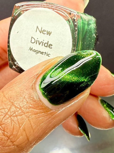 New Divide by Danglefoot Nail Polish, green shimmer jelly magnetic bottle held in a medium hand