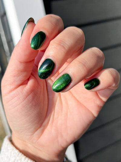 New Divide by Danglefoot Nail Polish, green shimmer jelly magnetic on a light skin tone hand