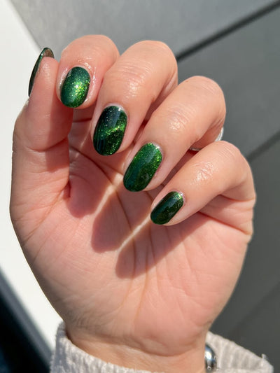 New Divide by Danglefoot Nail Polish, green shimmer jelly magnetic on a light skin tone hand