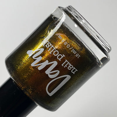 Ox by Dam Nail Polish, deep olive-brown shimmer showing dark brown-to-bright gold angle shift, bottle standalone product shot