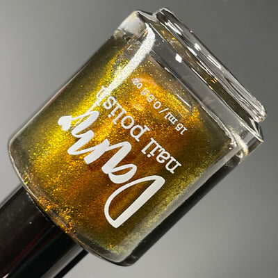 Ox by Dam Nail Polish, deep golden-brown shimmer with gold-to-bronze metallic shift, bottle standalone product shot