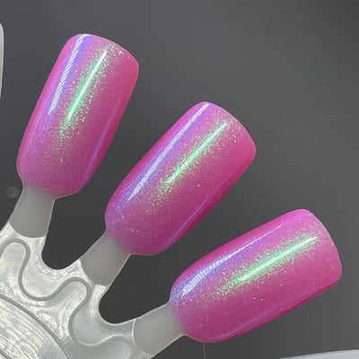 Pig by Dam Nail Polish, magenta-pink jelly base with green-to-blue-violet multichrome shimmer, swatch stick
