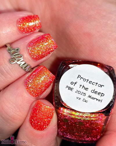 Protector of the Deep by Danglefoot Nail Polish, orange-pink reflective shimmer glitter bottle held in a light hand