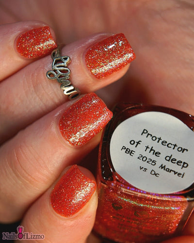 Protector of the Deep by Danglefoot Nail Polish, orange-pink reflective shimmer glitter bottle held in a light-medium hand