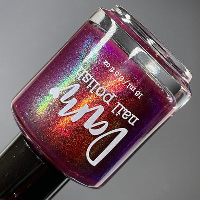 Should I Stay by Dam Nail Polish, deep fuchsia-plum jelly with gold, green, and violet-blue multichrome shimmer flakies, bottle standalone product shot