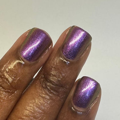 Thorn by 'Ard As Nails, magenta-violet multichrome chrome with pink and olive-gold duochrome shift in studio lighting, on a deep skin tone hand