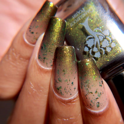 Succumb to the Fear by Danglefoot Nail Polish, black-gold multichrome shimmer flakie thermal on a light-medium skin tone hand