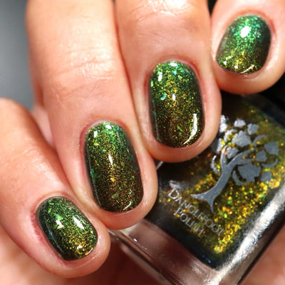 Succumb to the Fear by Danglefoot Nail Polish, black-gold multichrome shimmer flakie thermal on a light-medium skin tone hand