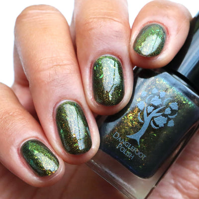 Succumb to the Fear by Danglefoot Nail Polish, black-gold multichrome shimmer flakie thermal on a light-medium skin tone hand