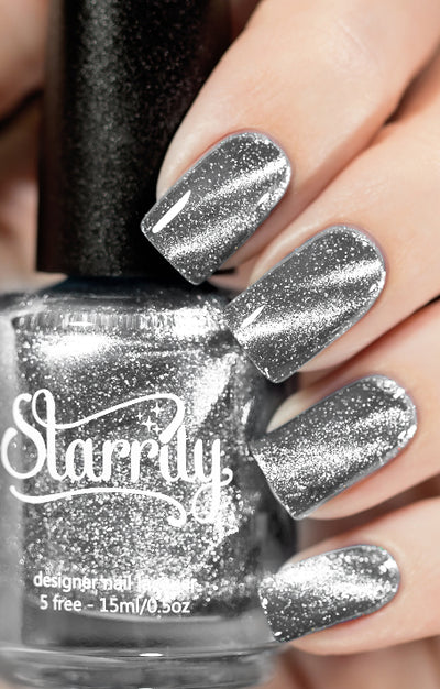 Amulet by Starrily, silver foil magnetic topper with densely packed reflective shimmer particles and 3D cat-eye streak, bottle held in a light hand
