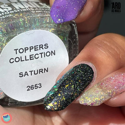 Saturn by 'Ard As Nails, holographic multichrome flakie topper mid-shift from green to gold over black base alongside white, purple, and bare nail bases, layering demo