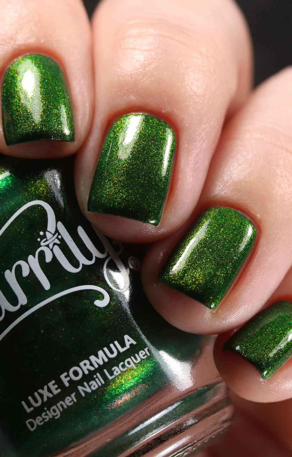 Artemis by Starrily, forest green with intense copper-gold metallic shimmer particles in studio lighting, on a light skin tone hand