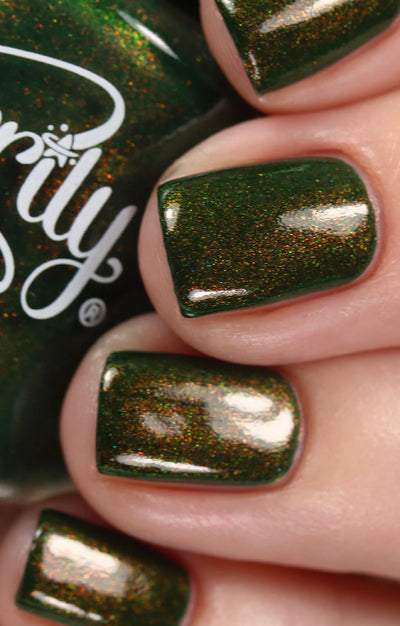 Artemis by Starrily, forest green with dense microflake shimmer shifting from warm copper to gold-green, glossy topcoat applied, on a light skin tone hand
