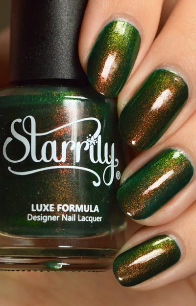 Artemis by Starrily, forest green shimmer with copper-to-green shift flashing copper in bright daylight, bottle held in a light hand