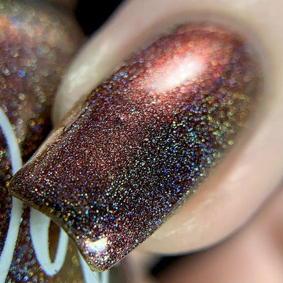 Change of Heart (Holo) by Dam Nail Polish, macro close-up of deep burgundy-black base with vivid red-to-orange shift and dense scattered rainbow holographic particles on nails