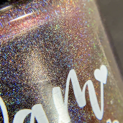 Change of Heart (Holo) by Dam Nail Polish, macro close-up of deep black-red base with russet-to-orange multichrome shift and dense gold holographic sparkle under direct flash