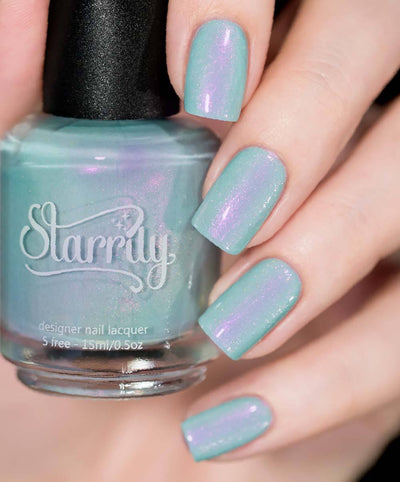 Clockwork Roses by Starrily, mint seafoam creme with strong pink-purple iridescent shimmer and holographic micro flecks, bottle held in a light skin tone hand