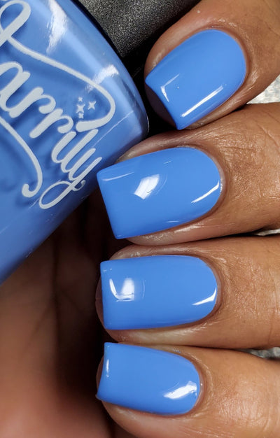 Cloudscape by Starrily, bright cornflower blue creme, glossy and fully opaque, on a medium-deep skin tone hand