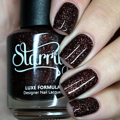 Into The Woods by Starrily, deep dark brown holographic with reddish-copper micro-flake shimmer in studio light, bottle held in a light skin tone hand
