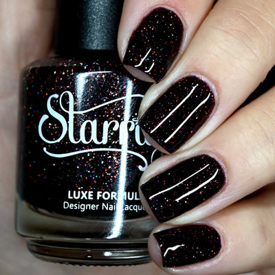 Protostar by Starrily, deep red-black base with scattered copper holographic micro glitter in studio light, bottle held in a light hand