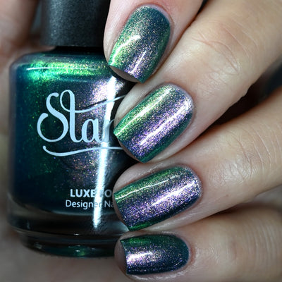 Sleepy Hollow by Starrily, deep forest green shimmer shifting dramatically to violet-purple at angle, bottle held in a light skin tone hand