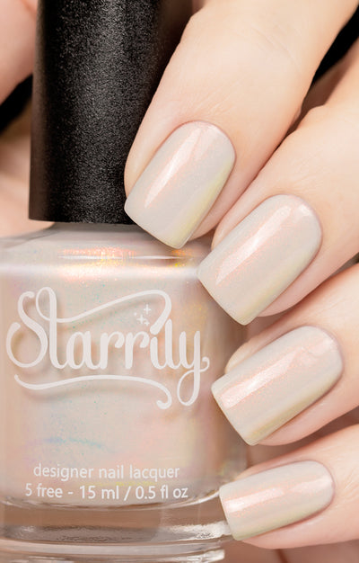 Daisy by Starrily, sheer white-grey shimmer shifting from orange to yellow-green, bottle held in a light hand
