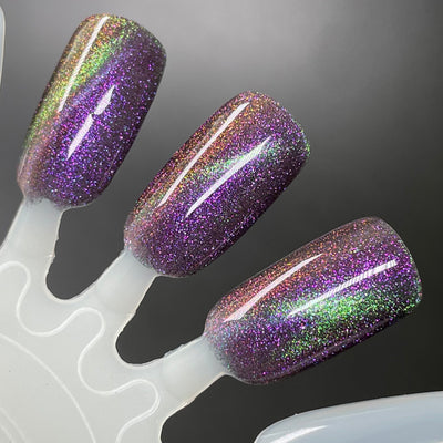 Distant Dimensions by Dam Nail Polish, gold-green multichrome magnetic showing purple-to-gold-to-green shift with linear magnetic stripe, swatch stick