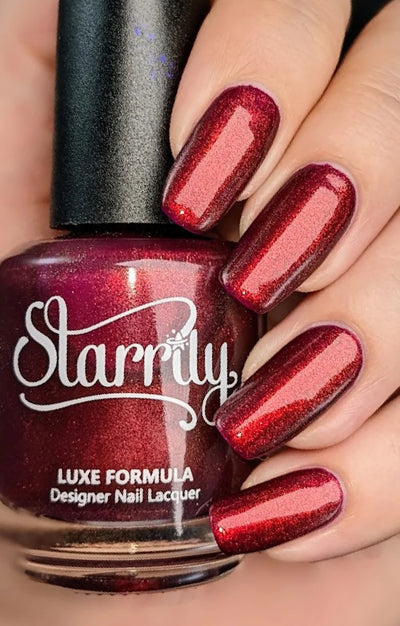 Dragon by Starrily, purple base with vivid copper-to-red color-shifting shimmer, purple undertone visible in shadows, bottle held in a light hand