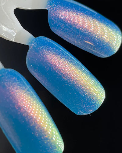 GTFO My Uterus by Dam Nail Polish, cornflower blue multichrome shimmer shifting pink-red to gold to green under direct flash, swatch stick