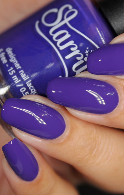 Gravity by Starrily, vivid medium violet-purple glossy creme, bottle held in a light skin tone hand