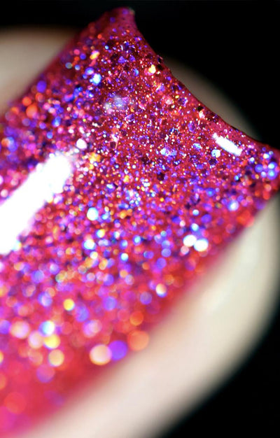 High Maintenance by Starrily, macro close-up of densely packed hot pink holographic glitter showing violet-to-orange prismatic spectrum flash