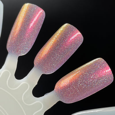 I Wear ❤️ On My Nails by Dam Nail Polish, pink holographic shimmer with pink-to-gold multichrome shift and dense holographic flake scatter, swatch stick