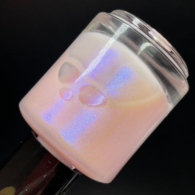 A Whimsical Dream by Dam Nail Polish, sheer milky pink base with color-shifting blurple iridescent shimmer, bottle standalone product shot