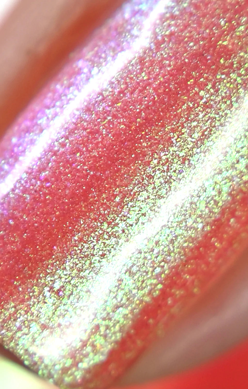 Nectar by Starrily, macro close-up of dense holographic microflakes shifting from coral-red pink to green, gold, and purple under direct flash