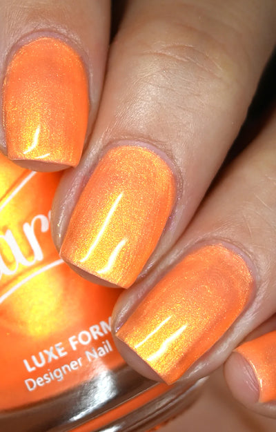 Peach Glow by Starrily, vivid orange base with gold to warm amber shimmer shift in daylight, on a light-medium skin tone hand