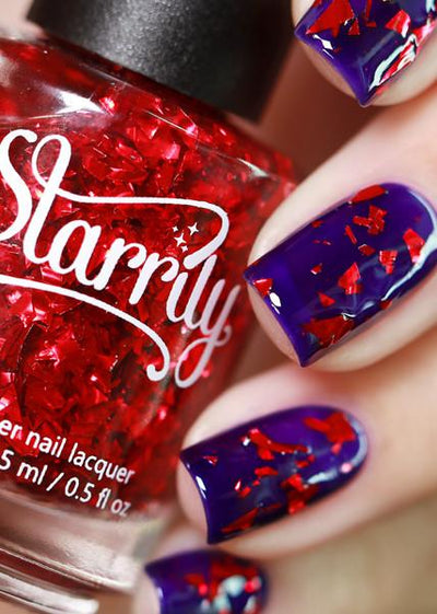 Rose Petals by Starrily, ruby red large-shard glitter topper over a deep violet-purple creme base, layering demo on a light skin tone hand