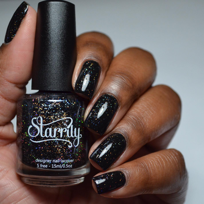 Neutrino by Starrily, jet black base with scattered silver and gold holographic glitter particles, bottle held in a deep skin tone hand