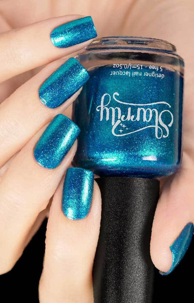 Skyline (Blue Foil) by Starrily, bright teal-blue metallic foil finish with micro flakie shimmer across both hands, bottle held in a light hand