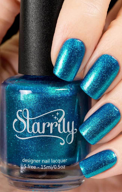Skyline (Blue Foil) by Starrily, teal-blue metallic micro flakie showing blue-to-cyan iridescent shift, bottle held in a light hand