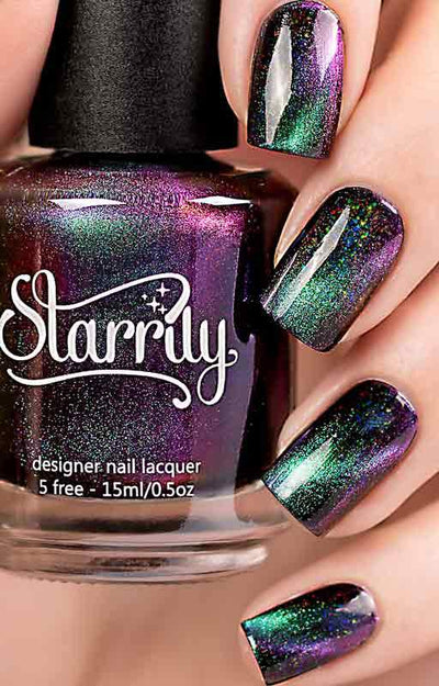 Dark Energy by Starrily, holographic multichrome magnetic with deep black-purple base shifting to emerald green, 3D magnetic effect activated, bottle held in a light-medium hand