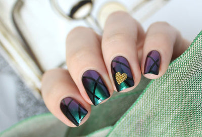 Death Wish by Starrily, multichrome applied over black showing deep purple-to-teal-green shift, on a light skin tone hand