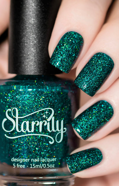 Everest by Starrily, deep teal-green holographic jelly with rainbow-shifting microflakes under direct flash, bottle held in a light skin tone hand
