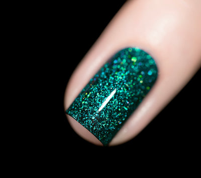 Everest by Starrily, densely packed teal-green holographic jelly with scattered blue and gold iridescent flake flash, on a light skin tone hand