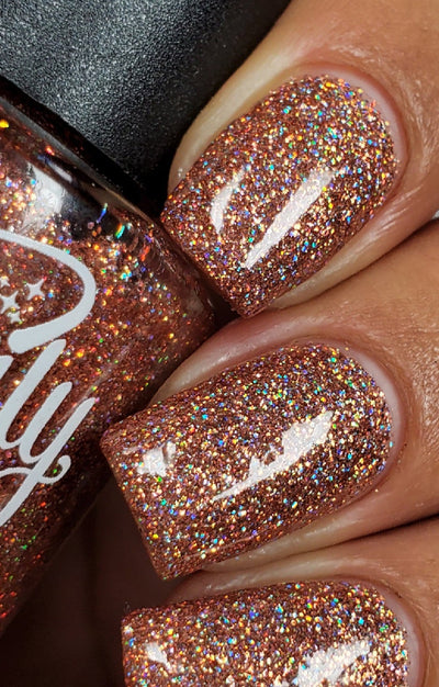 Penny by Starrily, dense copper-brown micro holographic glitter with multispectral rainbow scatter in daylight, on a light-medium skin tone hand