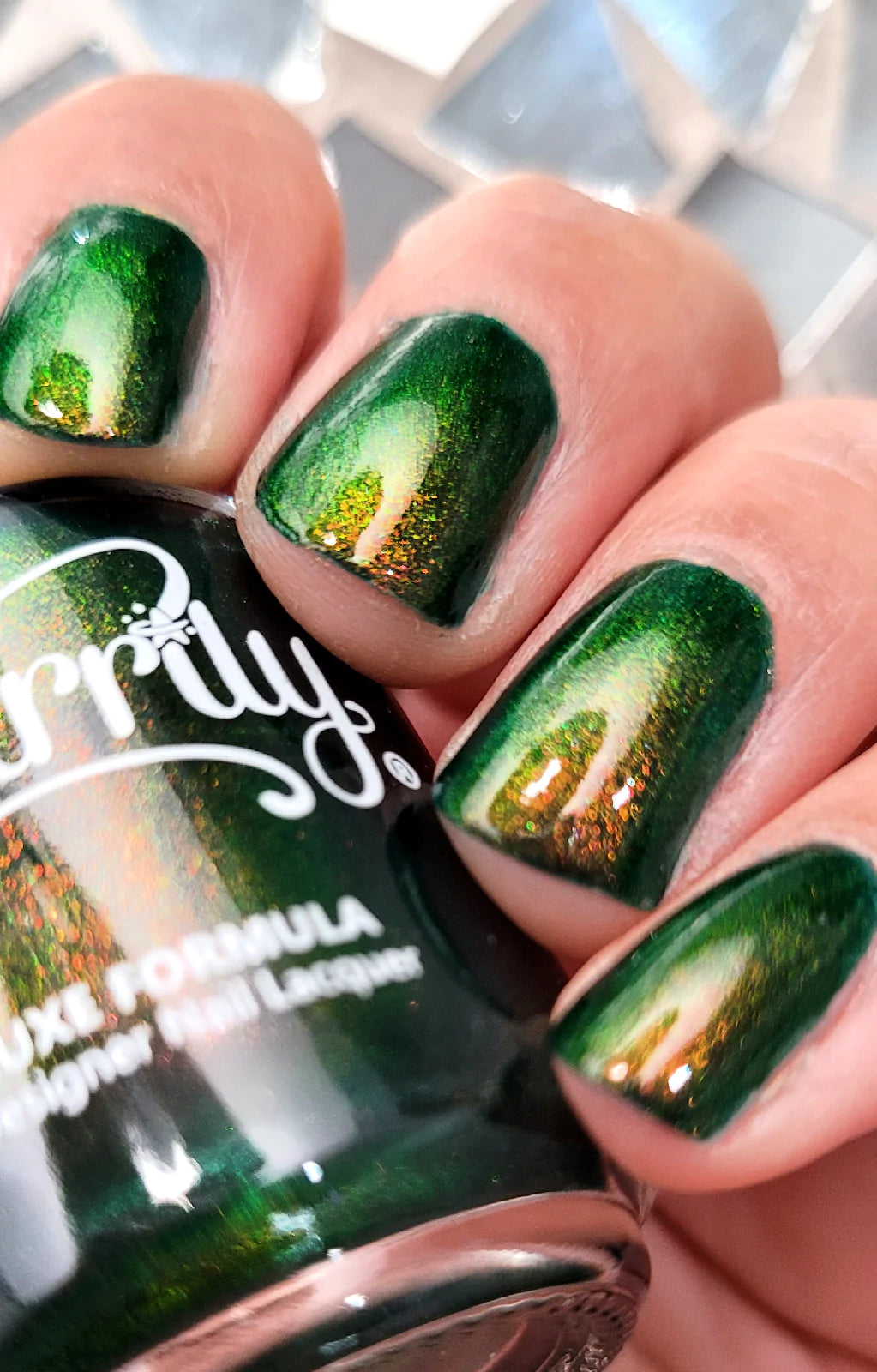 Artemis by Starrily, forest green multichrome shimmer with copper-to-gold-to-green shift in bright daylight, on a light skin tone hand