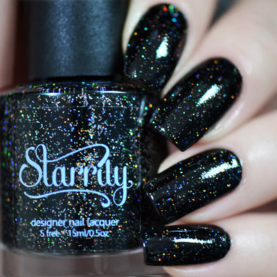 Neutrino by Starrily, jet black holographic glitter with vivid rainbow and fire-tone spectral scatter, bottle held in a light skin tone hand