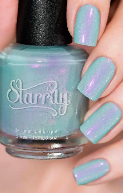 Clockwork Roses by Starrily, mint seafoam creme with pink-purple duochrome shimmer and holographic micro flecks, bottle held in a light skin tone hand