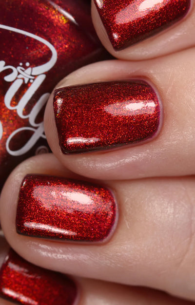 Dragon by Starrily, purple base reading fiery copper-red under direct flash, deep burgundy-purple in shadow areas, on a light skin tone hand