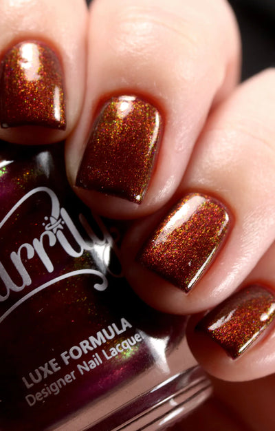Dragon by Starrily, purple shimmer shifting copper-orange to green at angles under direct flash, on a light skin tone hand